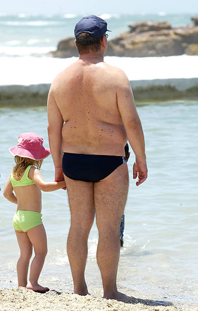 father and daughter on beach stock photo