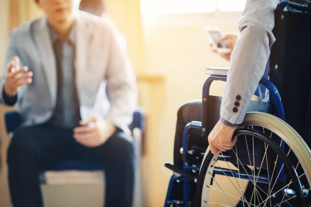 Man on wheelchair with his boss. After car accident and rehabilitation, a businessman can return to work again. The company which employing disable people will receive tax deductions benefits. again stock pictures, royalty-free photos & images