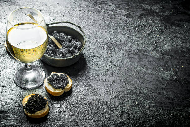 istock Black caviar in a bowl with sandwiches and wine. 1144173589
