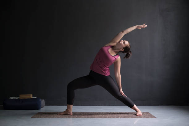 istock woman practicing yoga, doing Virabhadrasana 2 variation, Warrior one pose 1144173886