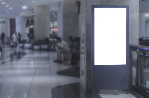 istock blank billboard white screen LED with clipping path vertical advertising ad banner board indoor in supermarket with blur people background. 1144173926