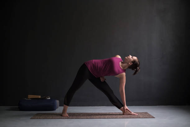 istock Girl standing in Utthita Trikonasana, extended triangle pose. 1144173951