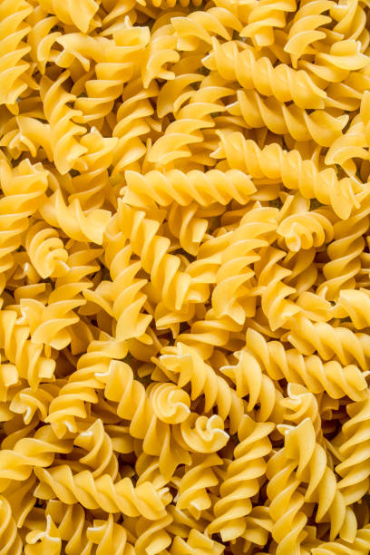 istock Pasta background. Dry pasta fusilli. 1144174285