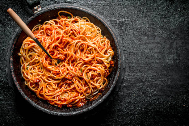 istock Pasta spaghetti with Bolognese sauce in the old pan. 1144175178