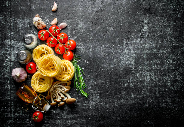 istock Tagliatelle raw with oil, garlic, tomatoes and spices. 1144175275