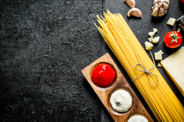 istock Raw spaghetti with Parmesan and different sauces. 1144175361
