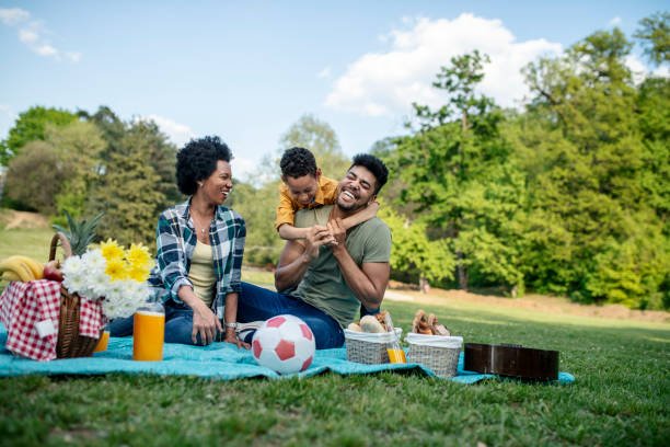 familia feliz pasando un día de primavera en picnic - family american culture black child fotografías e imágenes de stock