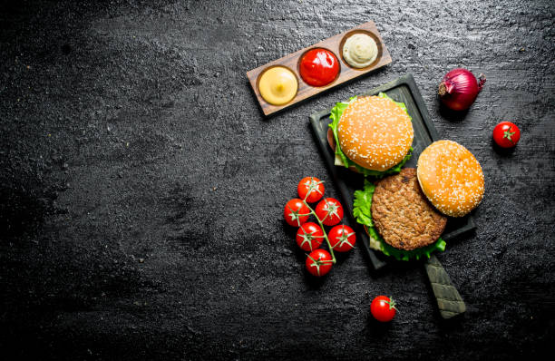 istock Burgers with tomatoes,sauces and onions. 1144177387