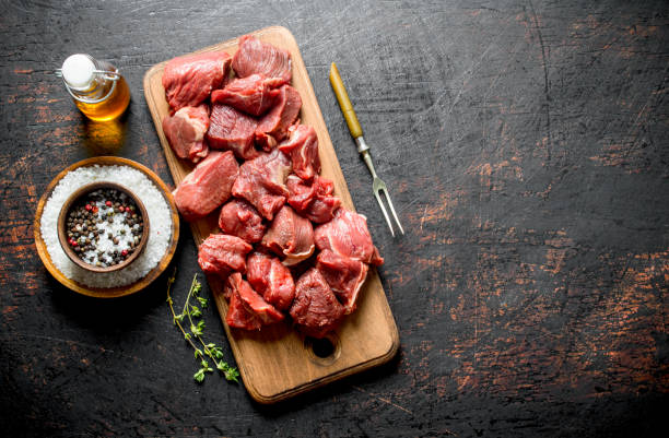 istock Sliced raw beef with rosemary, fork and bottled oil. 1144177625