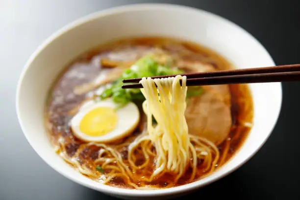 Photo of Ramen noodles in soy sauce flavored soup.