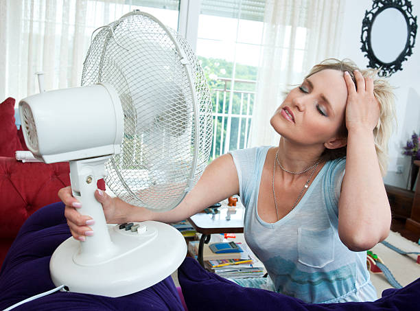 woman cooling herself stock photo