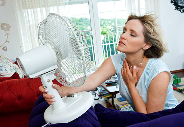 woman cooling herself stock photo