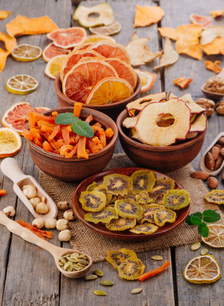 istock Mixed dried fruit chips, candied pumpkin slices, nuts and seeds on rustic wooden background 1144186982