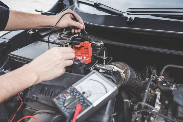 istock Services car engine machine concept, Automobile mechanic repairman hands checking a car engine automotive workshop with digital multimeter testing battery, car service and maintenance 1144187027