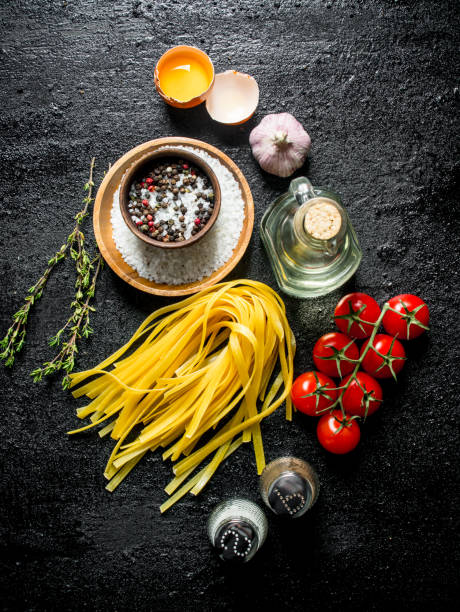 istock Raw home cooked pasta with spices, egg, oil and tomatoes. 1144190512