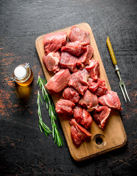 istock Sliced raw beef with rosemary, fork and bottled oil. 1144191071