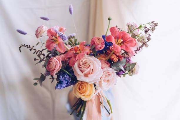 Jeune femme dans une robe bleue claire retenant un bouquet de fleurs. Concept romantique. - Photo