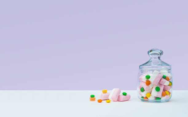 Marshmallow with dragee next to the glass transparent jar and in it