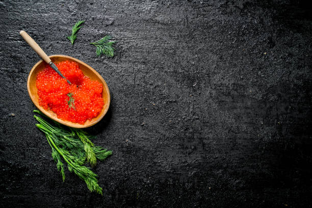 istock Red caviar in a bowl with a spoon and dill. 1144192848