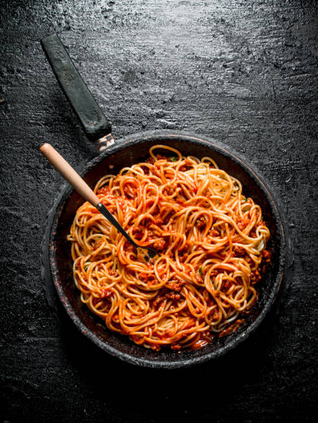 istock Pasta spaghetti with Bolognese sauce in the old pan. 1144194931