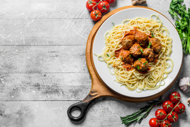 istock Spaghetti and meat balls on a plate with tomatoes, herbs and garlic. 1144195027