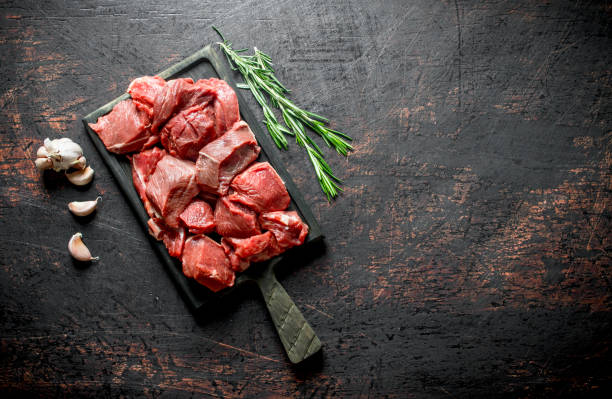istock Cut raw beef on a cutting Board with garlic and rosemary. 1144195288