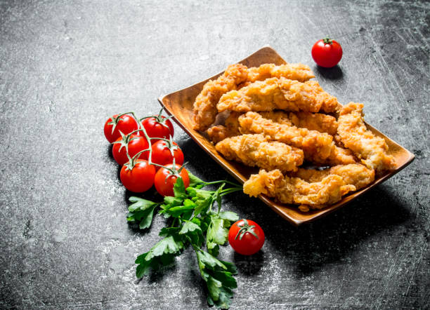 istock Chicken strips with parsley and cherry tomatoes. 1144195445