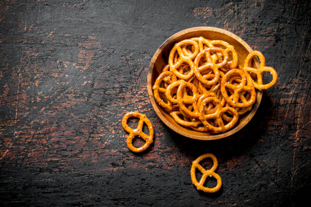 Snacks pretzels in a bowl. Snacks pretzels in a bowl. On dark rustic background pretzel photos stock pictures, royalty-free photos & images