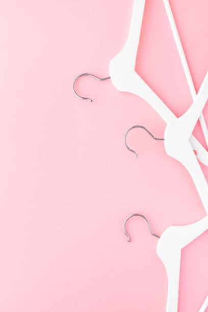 istock White hangers on pastel pink background 1144198060