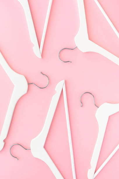 istock White hangers on pastel pink background 1144198070
