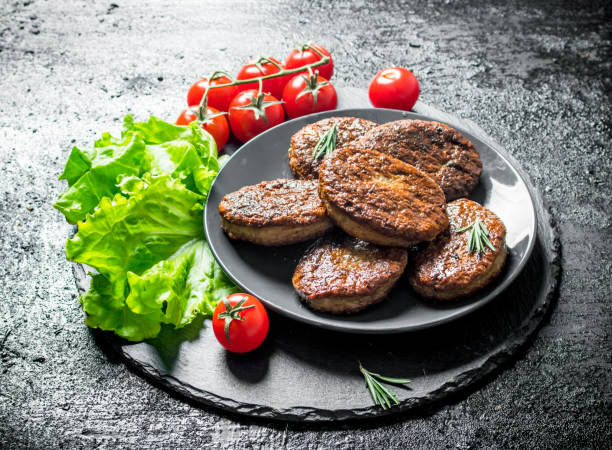 istock Cutlets with cherry tomatoes and salad leaves. 1144198077