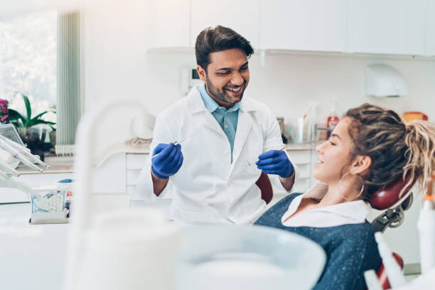 giovane donna durante un controllo dentale - dentist dental hygiene smiling patient foto e immagini stock