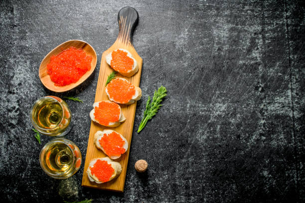 赤キャビアのサンドイッチ、キャビアのお椀とグラスのワイン。 - caviar salmon red gourmet ストックフォトと画像
