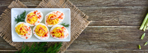istock Deviled eggs. Delicious appetizer. Boiled eggs stuffed with yolk, mustard, mayonnaise, paprika. Classic recipe. The top view. Banner 1144200796