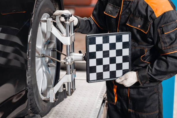 istock collapse-convergence. auto mechanic sets the car for diagnostics and configuration. Car Wheels alignment equipment on stand in a repair station 1144203792