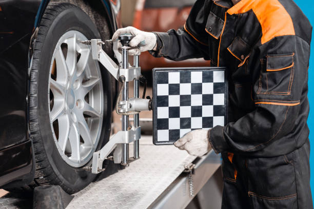 istock collapse-convergence. auto mechanic sets the car for diagnostics and configuration. Car Wheels alignment equipment on stand in a repair station 1144203864