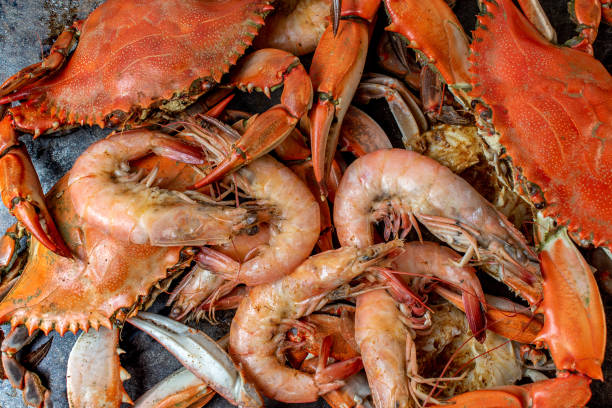 Group of steamed blue crabs and large shrimp in pile stock photo