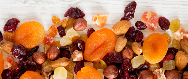 Dried fruits and nut mix on white wooden background, top view. Overhead, from above, flat lay.