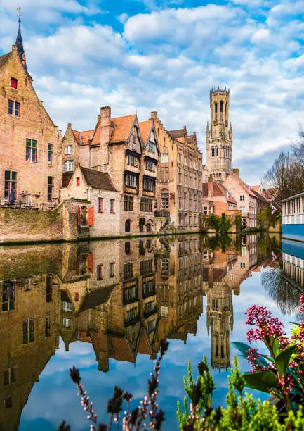 Landscape with famous Belfry tower and medieval buildings along a canal in Bruges, Belgium