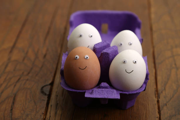 Chicken eggs with painted faces are in the box.