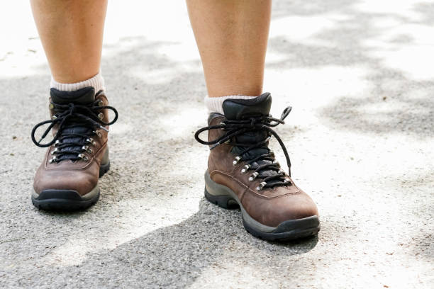 самка туриста связывая походы обуви - senior adult shoelace human leg leg �стоковые фото и изображения
