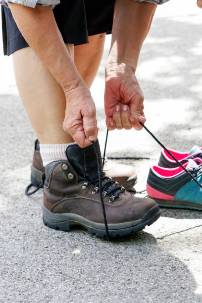 самка туриста связывая походы обуви - senior adult shoelace human leg leg стоковые фото и изображения