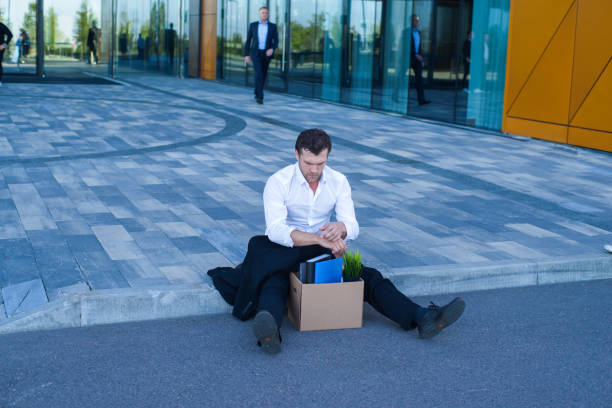 istock Fired businessman sitting on street 1144212380