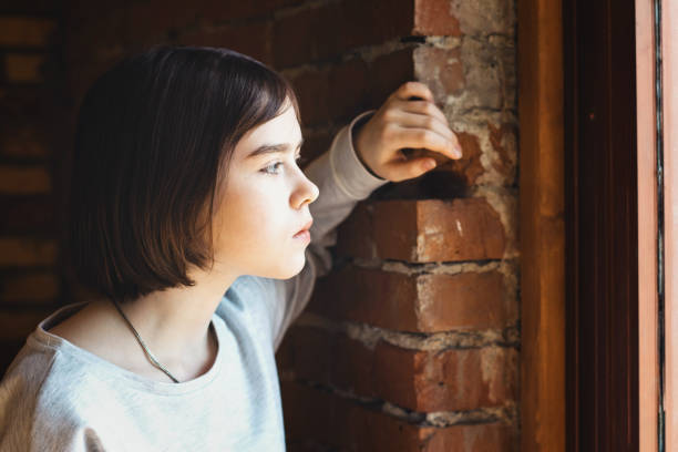 istock teenage gir on a brick wall background 1144214693