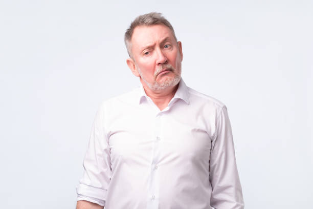 istock Old senior man in white shirt with serious and sad expression. 1144215652