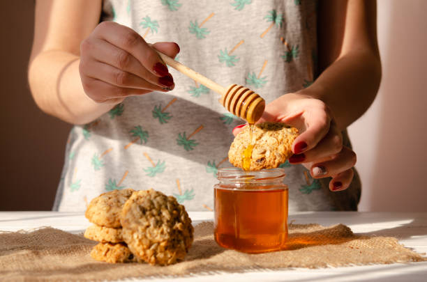The chef covers vegan biscuits with sesame and nuts with golden honey