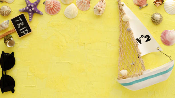istock Travel background. Traveler accessories,different shells, boat, starfish, sunglasses on yellow background.Travel concept.Summer flat lay. 1144218095
