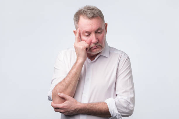 istock Sad senior man in white shirt thinking abour life. 1144218214