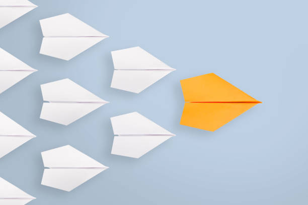 istock Leadership concepts with orange paper airplane leading among white 1144220849