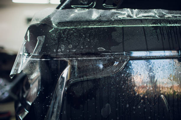 istock Worker hands installs car paint protection film wrap. 1144222925